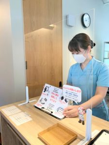 受付カウンターに飛沫防止のため仕切り版を置いています